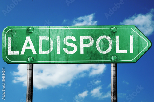 Ladispoli road sign, vintage green with clouds background