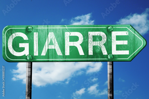 Giarre road sign, vintage green with clouds background photo