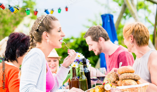 Photography Woman eating grilled sausage on bbq party