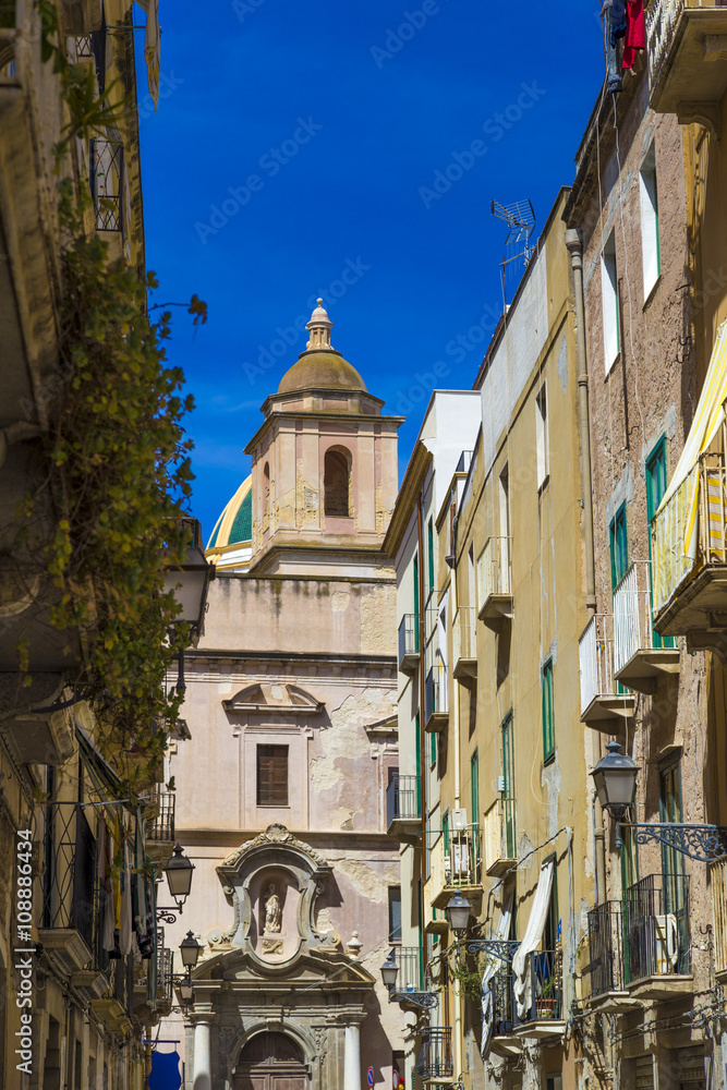 View of old street in Trapani, Sicily with cathedral dome in background