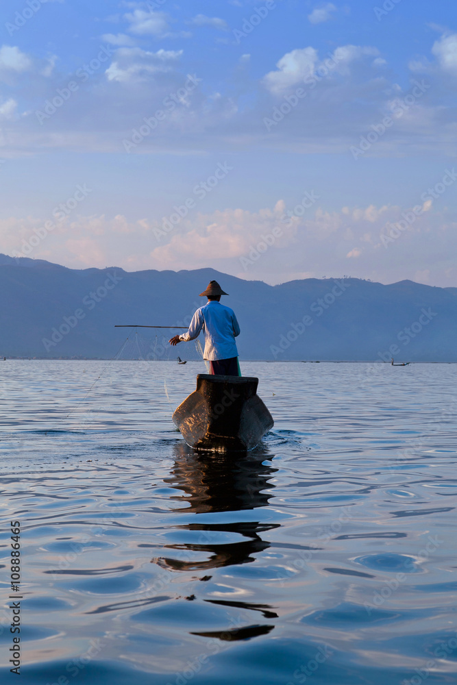 An unidentified Intha fisherman catches fish for food on Inle Lake, Shan state, Myanmar An unidentified Intha fisherman catches fish for food on Inle Lake, Shan state, Myanmar