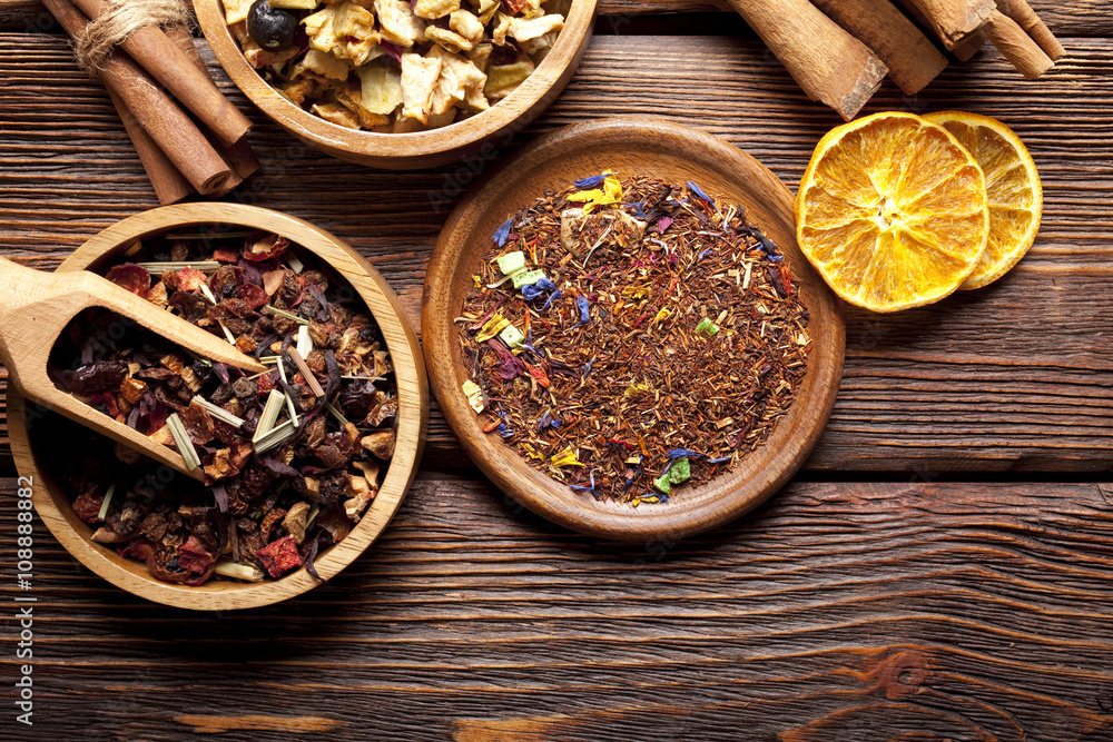 Various leaves of tea and spices on wooden background Various leaves of tea and spices on wooden background