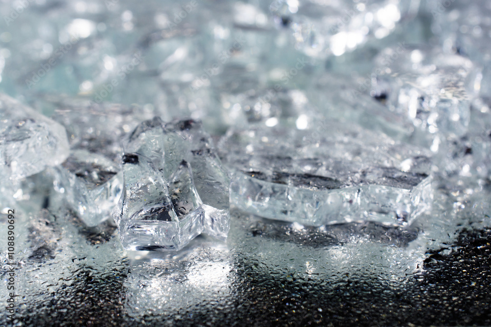 pile of different ice cubes on reflection table with water drops pile of different ice cubes on reflection table with water drops