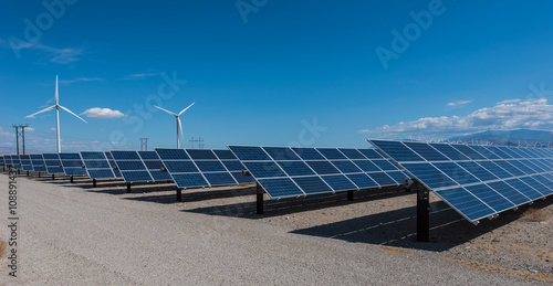 Solar panels and wind turbines in sunny desert