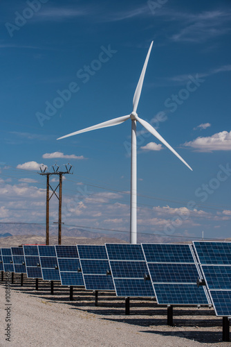 Solar panels and wind turbines in sunny desert