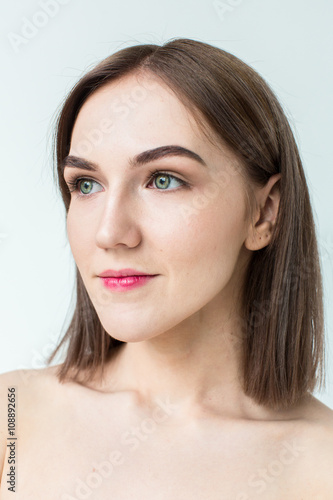 Beauty portrait of young model with middle length hair. Professional nude makeup. Green eyes.