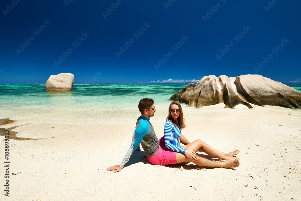 Couple at tropical beach wearing rash guard