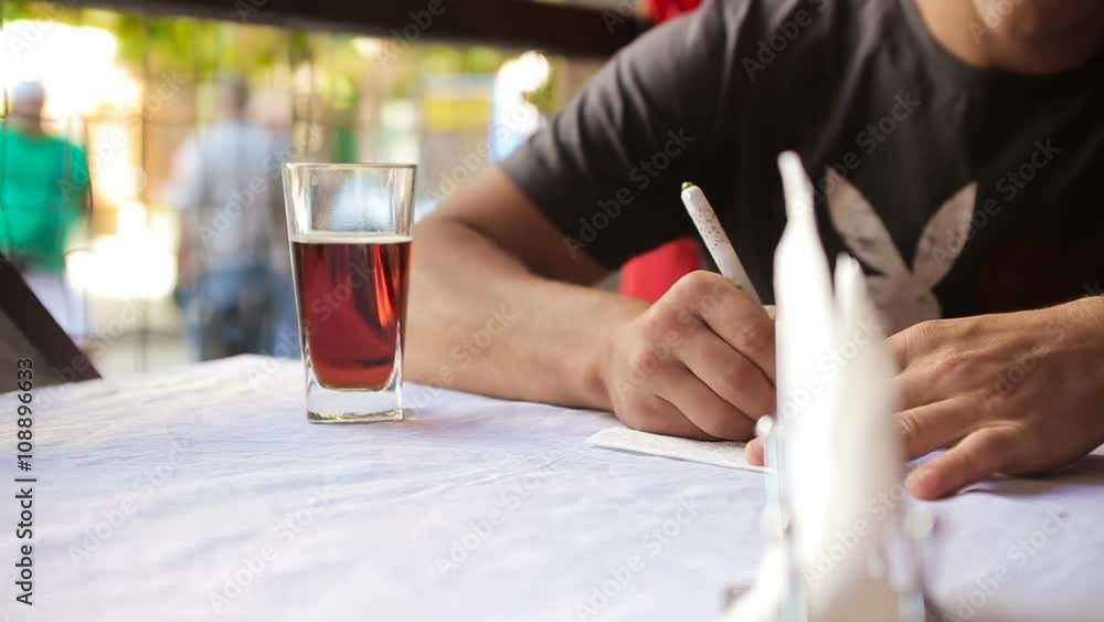 man writing notes in napkin