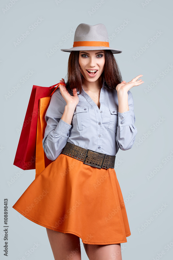 Shopping woman holding bags, isolated on gray studio background. Shopping woman holding bags, isolated on gray studio background.