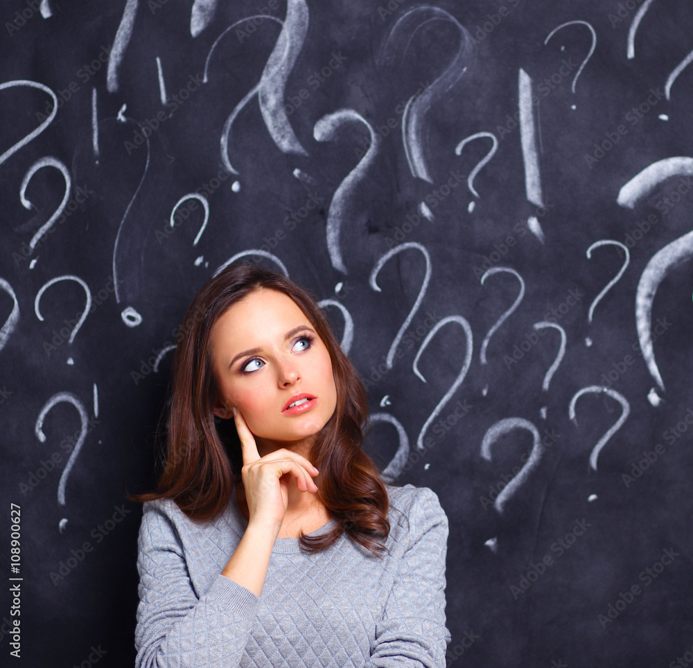 Young girl with question mark on a gray background Young girl with question mark on a gray background