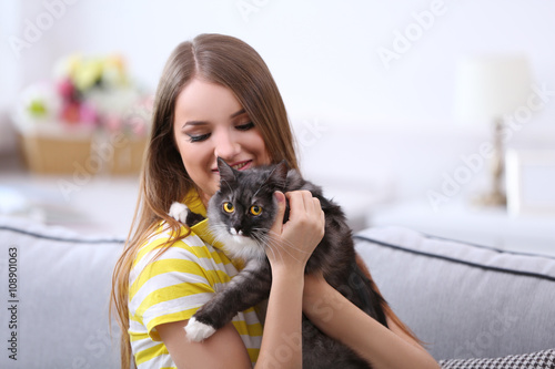 Beautiful young woman with cat at home © Africa Studio