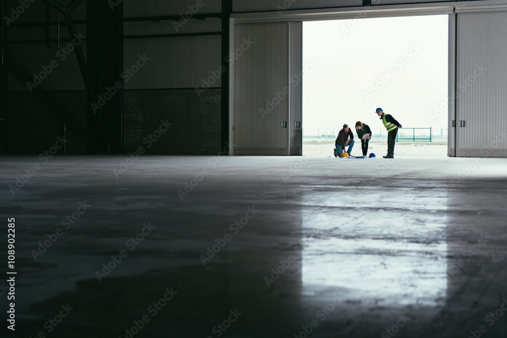 Obraz premium Architect team reading blueprint on work site