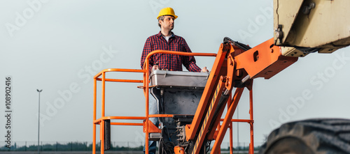 Foto Worker operating Straight Boom Lift