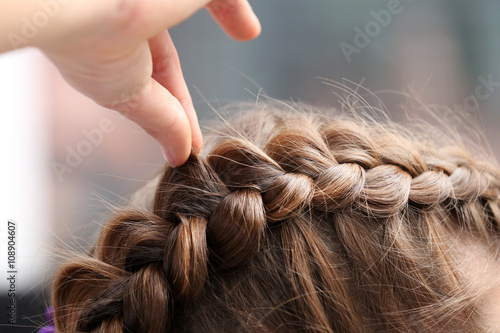 Canvas Print Professional hairdresser braiding clients hair