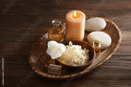 Spa set with sea salt  exotic flowers and candles on wicker tray