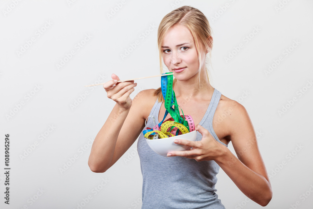 Diet. Girl with colorful measuring tapes in bowl Diet. Girl with colorful measuring tapes in bowl