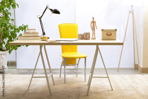 Workplace with table, yello...