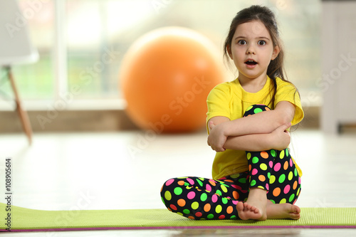 Little funny girl sitting o...