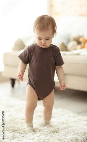 Baby walking along the room
