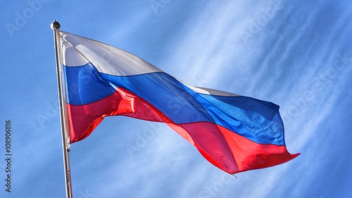 Flag of Russia. Russian Flag on Flagpole Waving in front of Blue Sky. photo