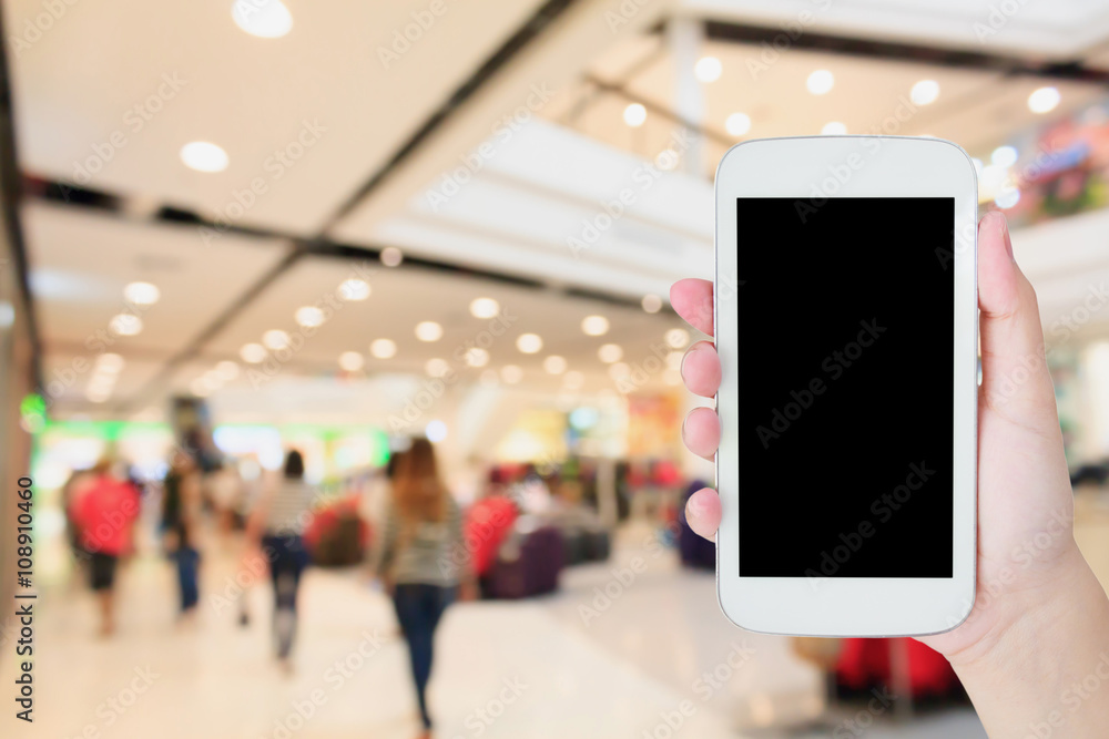 hand hold mobile phone with blurred shopping mall