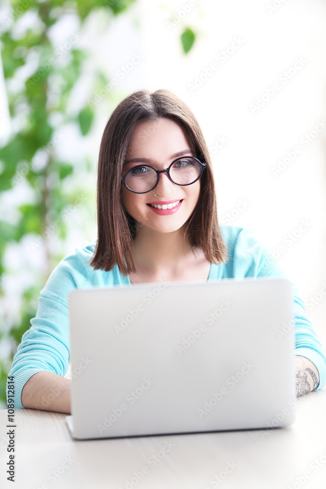 Woman sitting at the table and working with laptop Woman sitting at the table and working with laptop