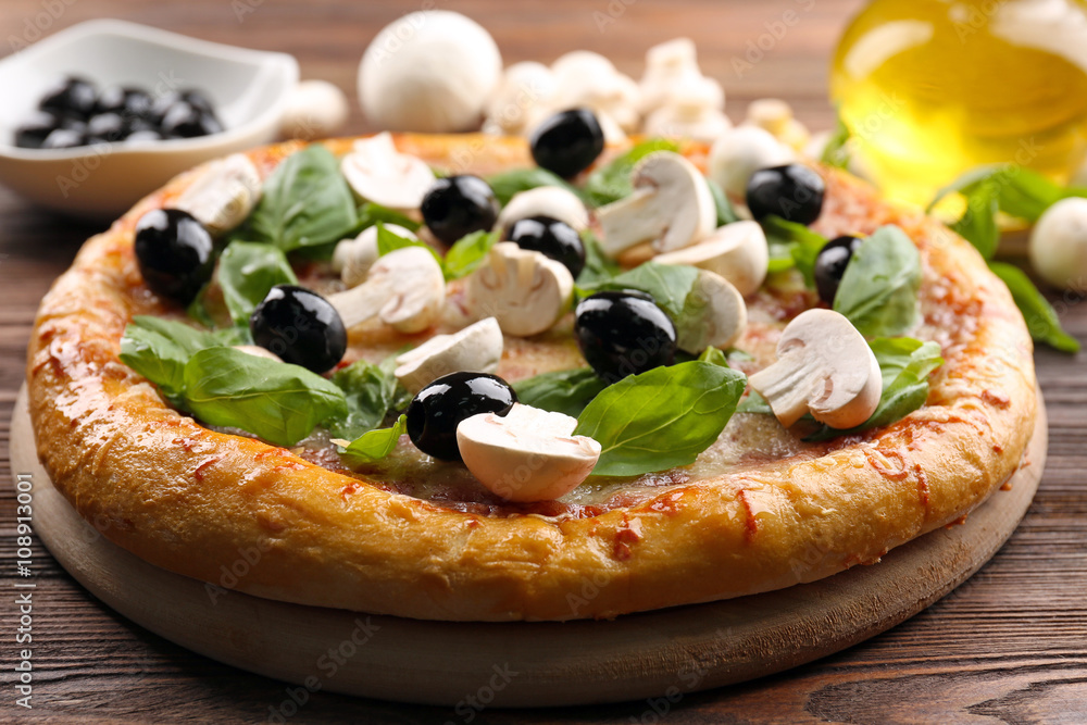 Delicious tasty pizza with ingredients on wooden table Delicious tasty pizza with ingredients on wooden table