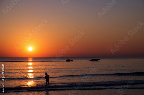 Sunset view at the beach with silhouette people