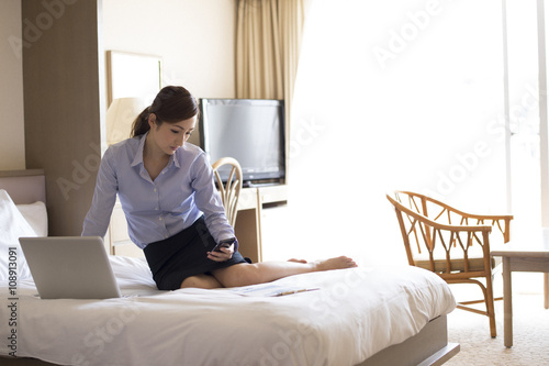 Women are waiting for the contact sitting in the business hotel bed