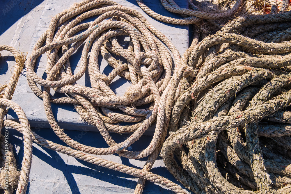Piles of old strong ropes on wooden boat