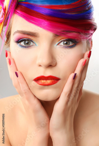Beautiful girl with colorful makeup  manicure and hairstyle