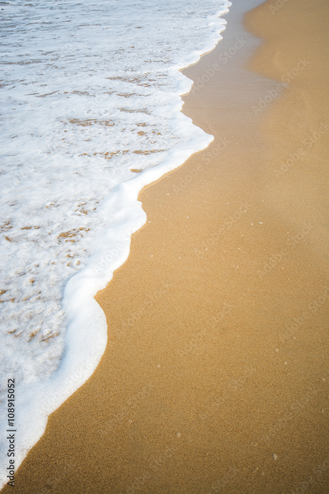 White wave on brown sand beach