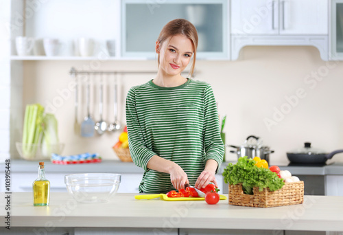 Young woman cutting vegetab...