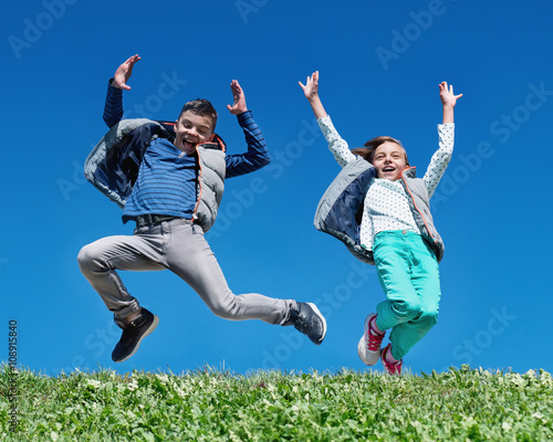 Happy children jumping on meadow