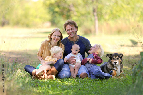 Happy Laughing Family of 5 People and Dog in Sunny Garden © Christin Lola