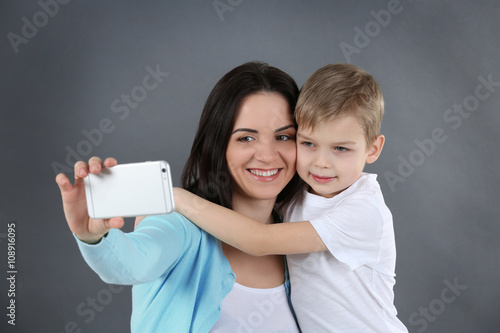 Smiling mom making selfie w...