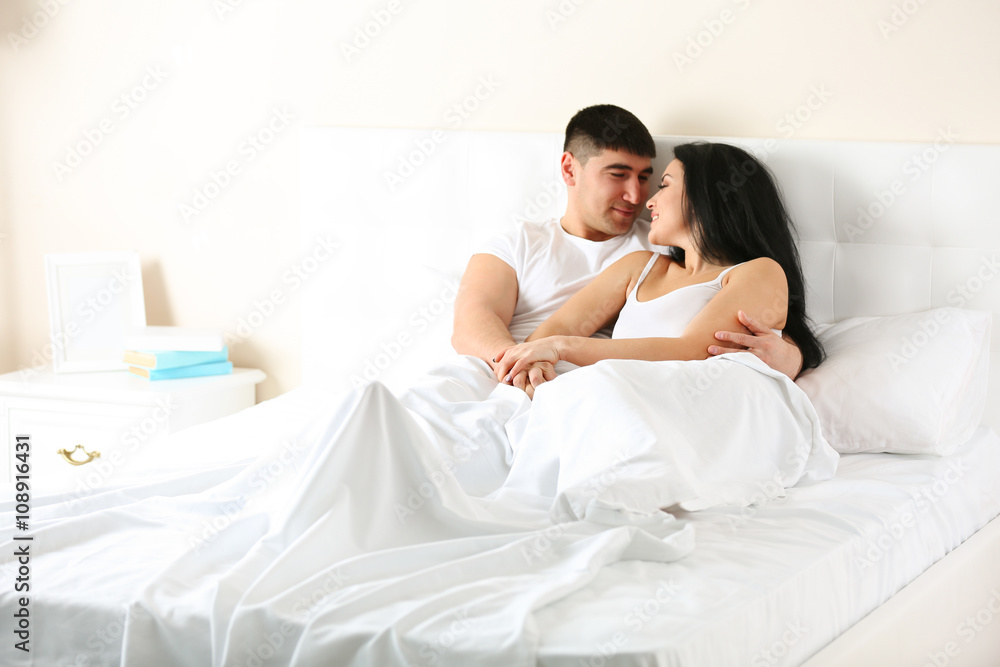Fototapeta premium Lovely couple in white bed