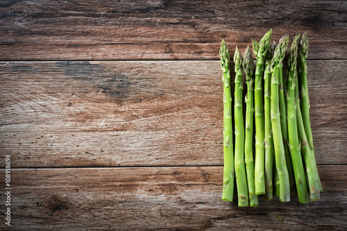 Bunch of fresh asparagus on wooden rustic background. Copy space