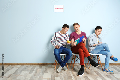 Three men waiting for interview indoors