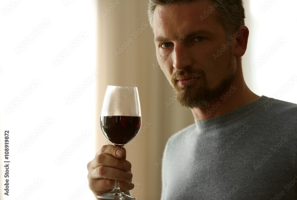 Handsome middle-aged man tasting red wine, close-up Handsome middle-aged man tasting red wine, close-up