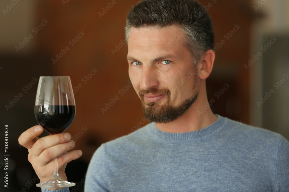 Handsome middle-aged man tasting red wine, close-up Handsome middle-aged man tasting red wine, close-up