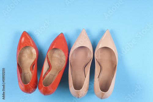 A picture of different shoes, Shot of several types of shoes, Several designs of women shoes. Leather Shoe. Pile of various female shoes on on light blue background. Copy space for text.