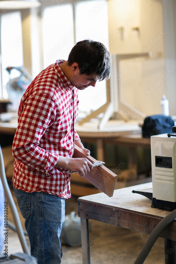 Carpenter measures the board thickness of the callipers, joiner' Carpenter measures the board thickness of the callipers, joiner'