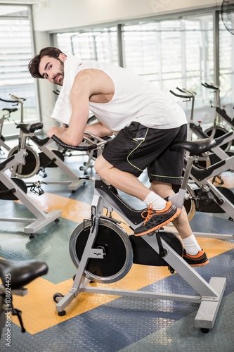 Fit man using exercise bike