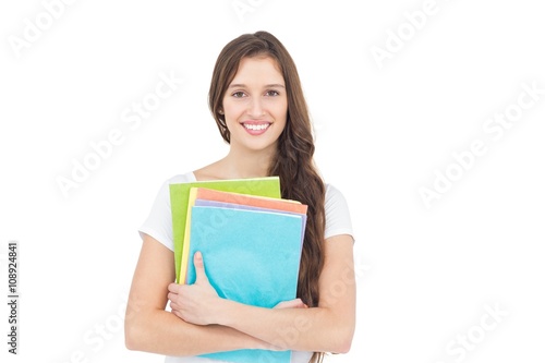 Portrait of smiling female college student holding books 