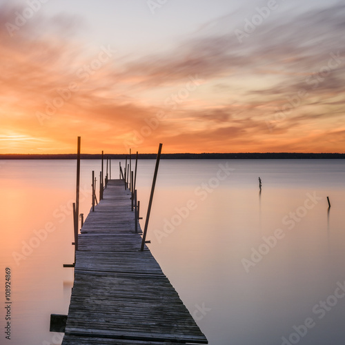 Wooden pier and lake at sunset photo