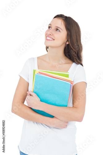 Smiling female college student holding books 