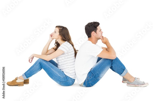 Thoughtful couple sitting on floor back to back