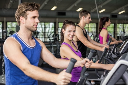 Fit people on elliptical bike