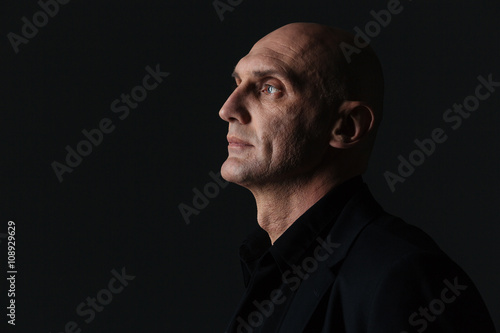 Schilderij op canvas Profile of attractive boldheaded businessman in dark suit